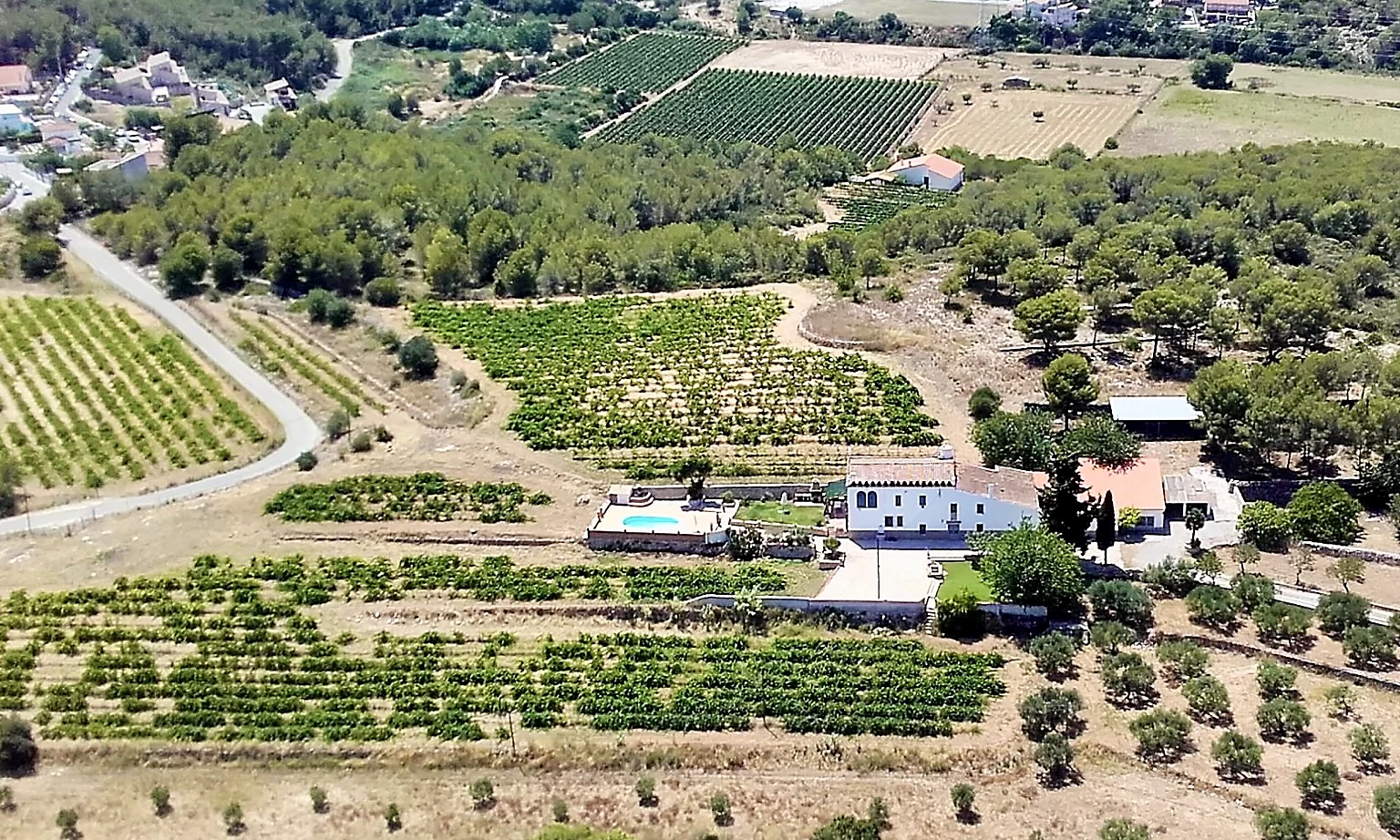 Aerial view of Masia St Salvador 1582 estate with vineyards, olive groves and pool in Cubelles near Sitges