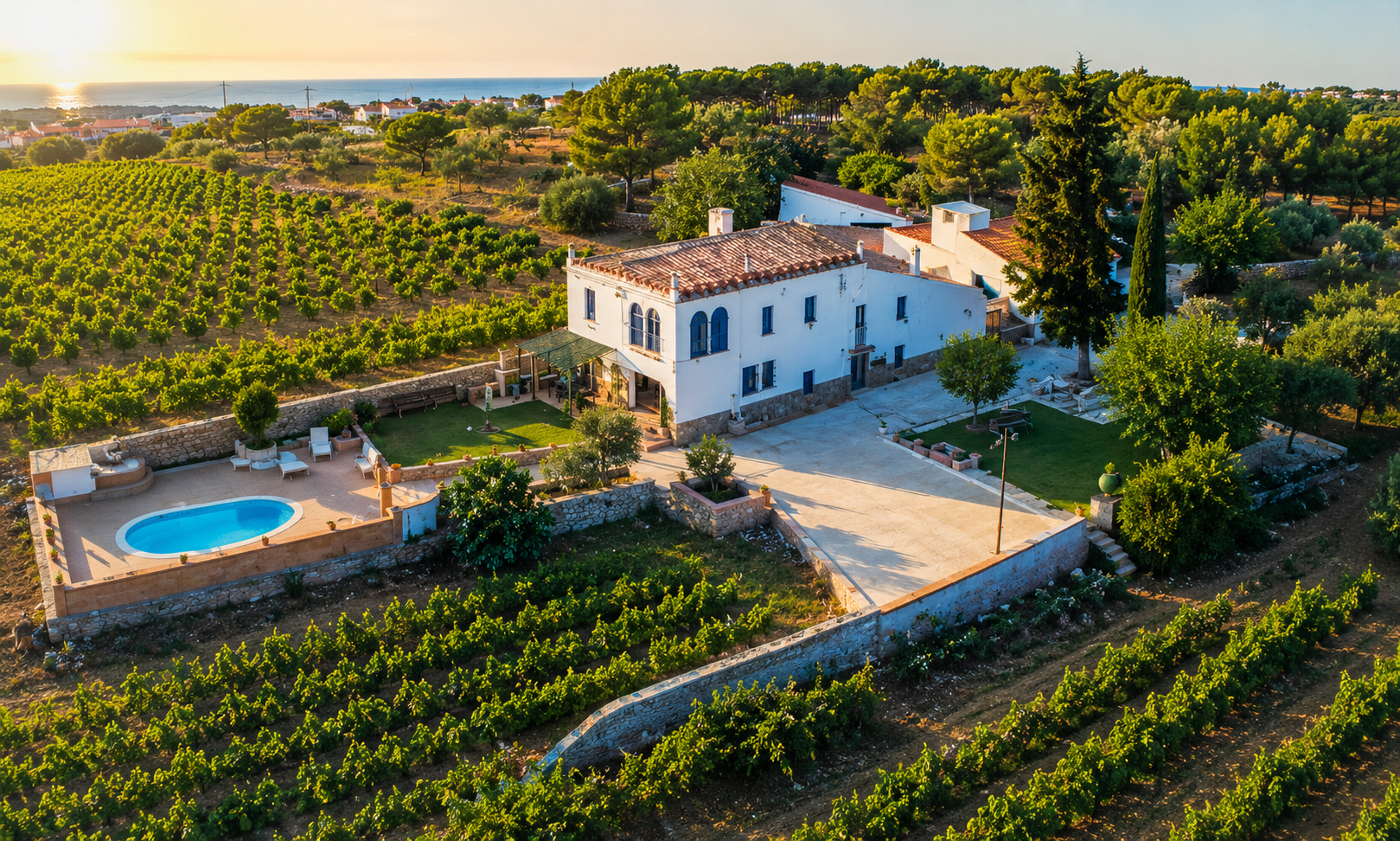 Aerial view of Masia St Salvador 1582 estate with pool, vineyards, and Mediterranean sea views near Sitges, Barcelona
